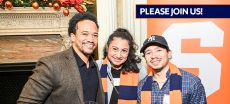 Three alumni. One with baseball cap and two with orange and blue scarves.