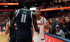 Basketball players Georgetown black jersey with white branding and SU white jersey with orange branding