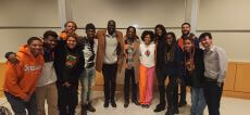 Group of students. One women with white top and orange slacks.