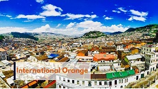 view of houses, mountains and skies with international orange font