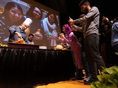 students at the thanksgiving dinner with a chef and a turkey