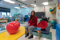 Madalyn Tallo in a classroom at her internship, surrounded by occupational therapy activities for students.