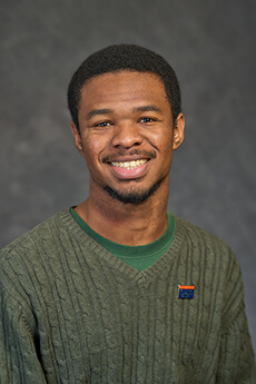 Student smiling with Green Sweater