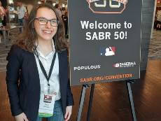 Woman standing in front of sign at conference