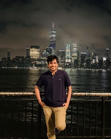 Gupta Shloak standing with water and building background