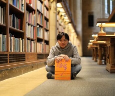 Hung Phung sitting in a library