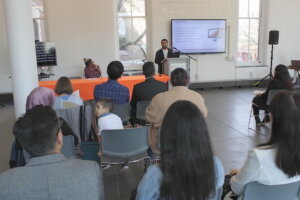 A doctoral student presenting research at a podium