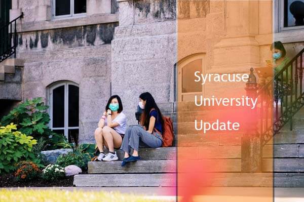 students with masks sititng on campus