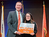 Hannah Rafferty '16, sport management alumna, stands alongside Vice Chancellor Mike Haynie on stage at the CUSE50 Awards
