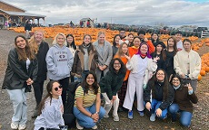 group of students with pumpkins on background