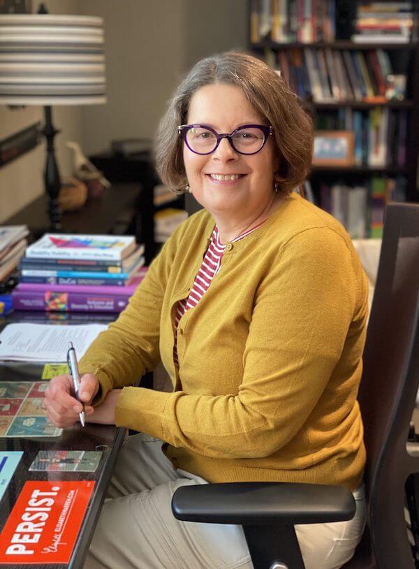 beth ferri sits at her desk