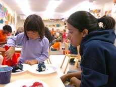 Student in a classroom with young children doing art projects.
