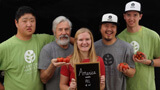 People holding fresh produce with a sign that reads, "America needs all of us!"