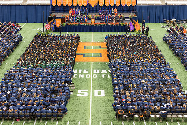 Graduating students sit in chairs on the Dome turf during the 2023 Commencement ceremony.
