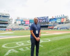 Coach Autry dressed in blue on field of Yankee Stadium