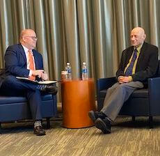 Two men in chairs looking at each other