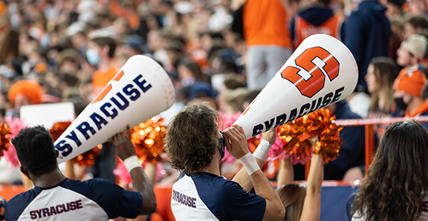 Cheerleaders using megaphones at football game to excite crowd